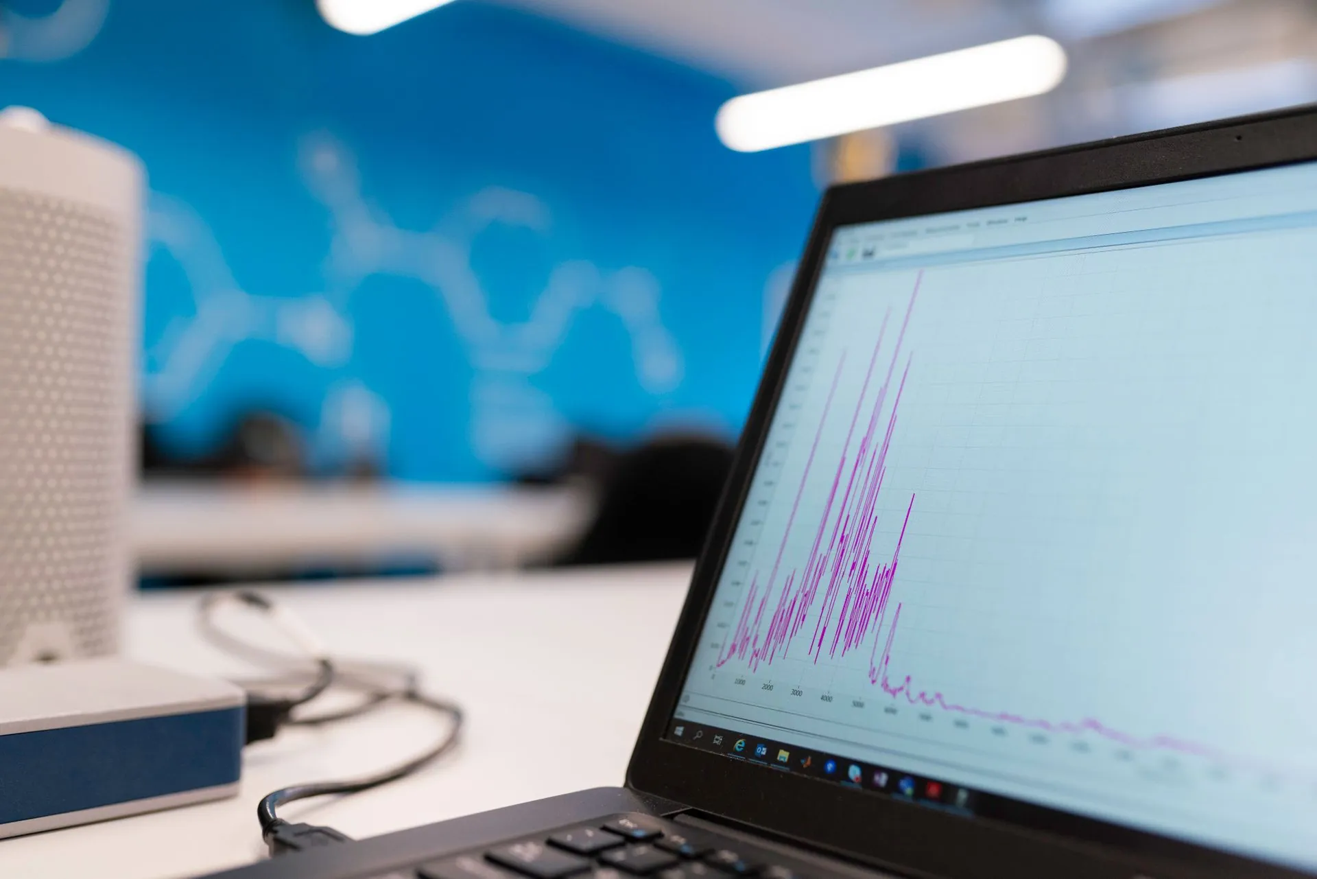 A laptop showing a line chart climbing across the screen.
