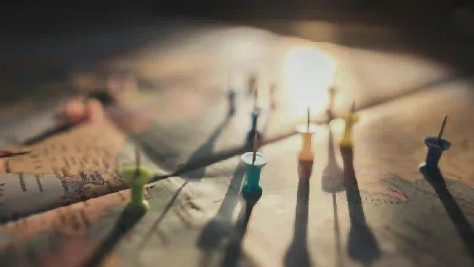 Filament bulbs strung in a row, one lit brighter than the rest.